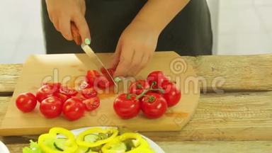 一个女人手里拿着<strong>一把</strong>刀，切樱桃西红柿做沙拉。